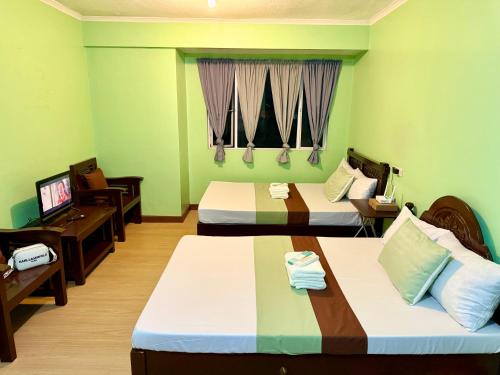 a hotel room with two beds and a television at Albergo Hotel - Studio Condo Unit - Baguio Transient in Baguio