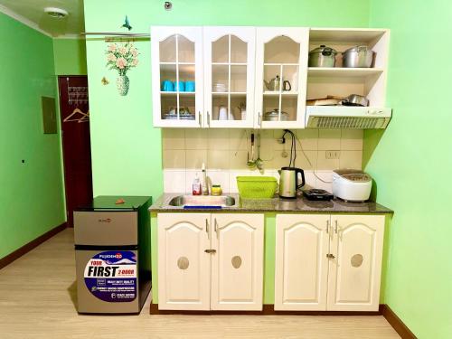 a kitchen with white cabinets and a box in a room at Albergo Hotel - Studio Condo Unit - Baguio Transient in Baguio