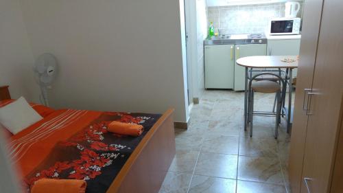 a bedroom with a bed and a table in a kitchen at Vasti Apartman in Siófok