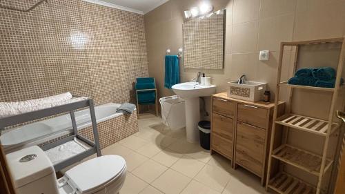 a bathroom with a toilet and a sink and a tub at Casinha no coração do Oeste in Cadaval