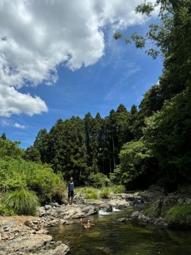 a man and two children swimming in a river at Osugi-ya 大杉屋 in Wazuka