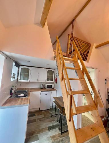 a staircase in a tiny house with a kitchen at Cosy Cart Shed in Evesham