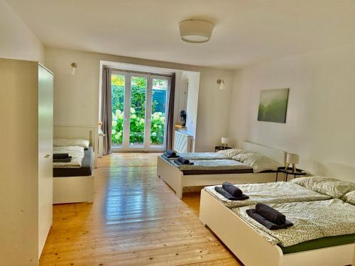 een slaapkamer met twee bedden en een groot raam bij Luxury 130 m2 Apartment with Garden in Wenen