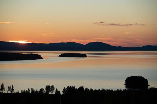a sunset over a large body of water at Green Hotel in Tällberg