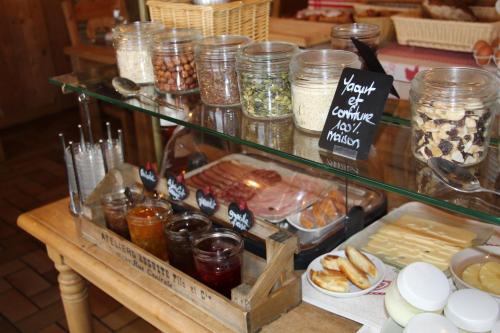 a table with a glass counter with food on it at Les 4 Saisons in Kruth