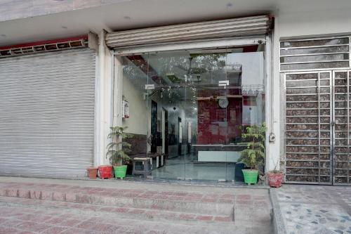 a window of a store with potted plants in it at Hotel NidhiVan Dham in Mathura
