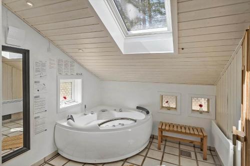 eine große weiße Badewanne im Bad mit Dachfenster in der Unterkunft 2652 Nexø - Væbnerstien 5 in Neksø