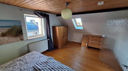 a bedroom with a bed and a dresser and two windows at Cozy apartment with S-Bahn connection to Frankfurt in Rödermark