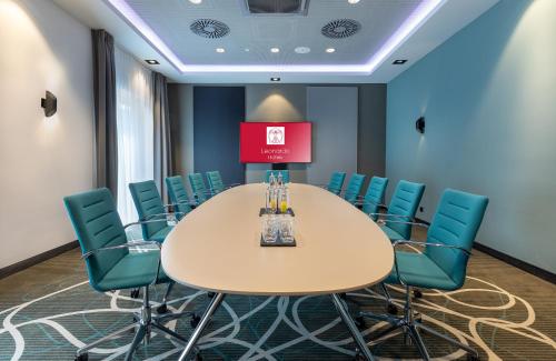 a conference room with a table and chairs at Leonardo Hotel Dortmund in Dortmund