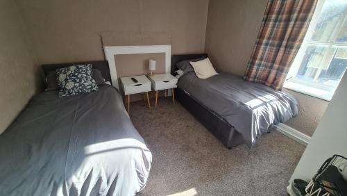 a bedroom with two beds and a mirror at The Bulls Head Hotel in Youlgreave