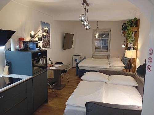 Una pequeña habitación con dos camas y una cocina. en Lidmansky 3 - Tinyhomes Klagenfurt, en Klagenfurt