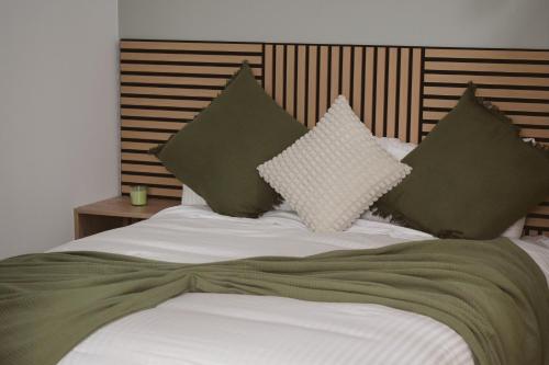 a bed with green and white pillows on it at Brisa del Mar in Tacoronte