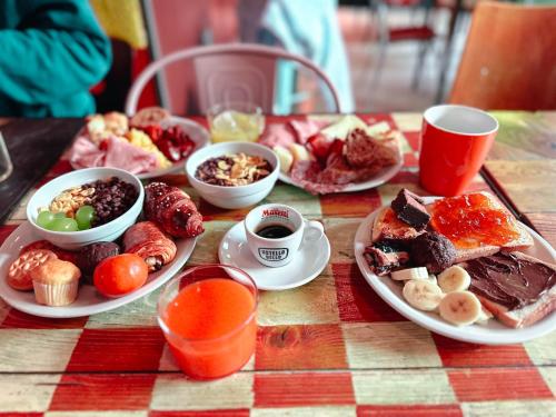 a table with plates of food and cups of coffee at Ostello Bello Milano Centrale in Milan