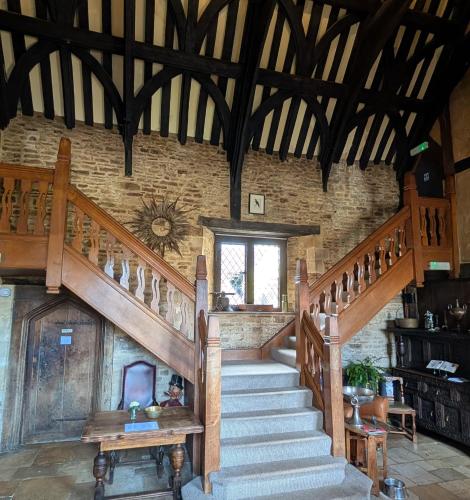 a wooden staircase in a room with a stone wall at The Crown at Shipton in Shipton under Wychwood