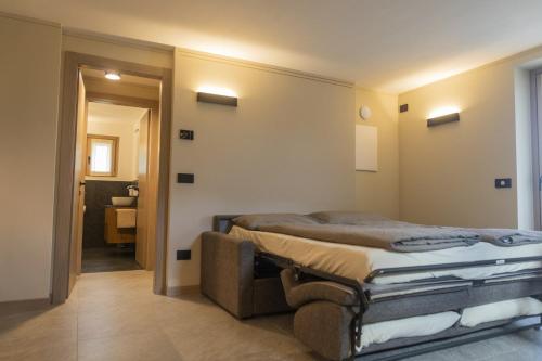 een slaapkamer met een bed en een deur naar een badkamer bij Baita della Valle -Appartamento Bucaneve- in Livigno