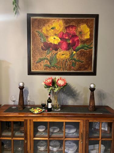 a painting of flowers on top of a cabinet at Luna Amour Villa in Pretoria