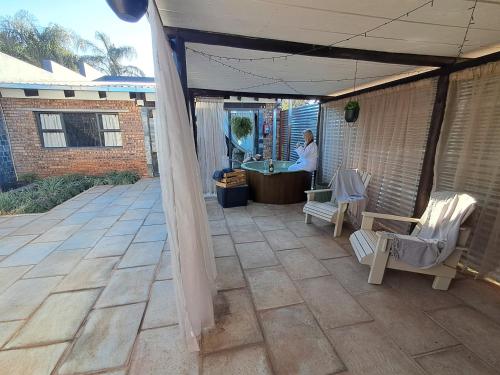 a person standing in a patio with a table and chairs at Luna Amour Villa in Pretoria