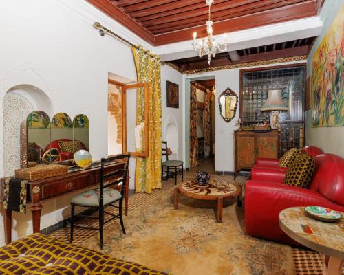 a living room with a red couch and a table at Dar Tya Rabat Salé Marina in Sale