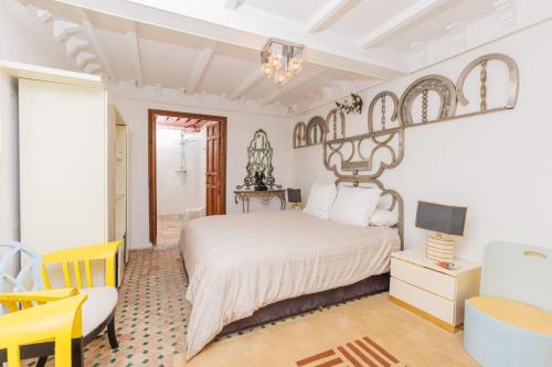 a bedroom with a white bed and a yellow chair at Dar Tya Rabat Salé Marina in Sale