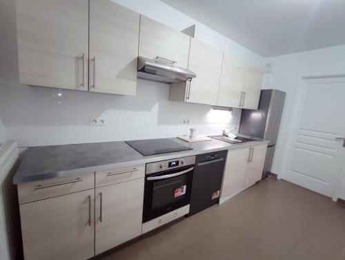 a kitchen with white cabinets and a black stove top oven at Charming 3 rooms with parking in Rueil-Malmaison