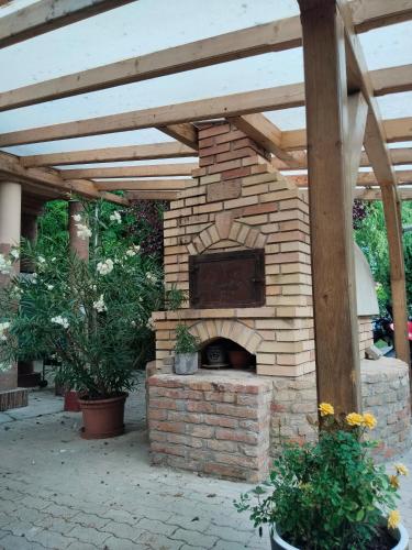 a brick oven in a patio with a roof at Hársfavirág Vendégház in Pápa