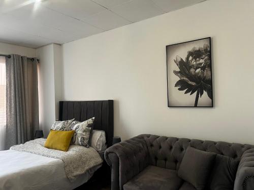 a living room with a couch and a bed at High Rise Haven in Johannesburg