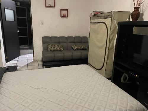 a living room with a couch and a bed at Centro Histórico Olas Altas in Mazatlán