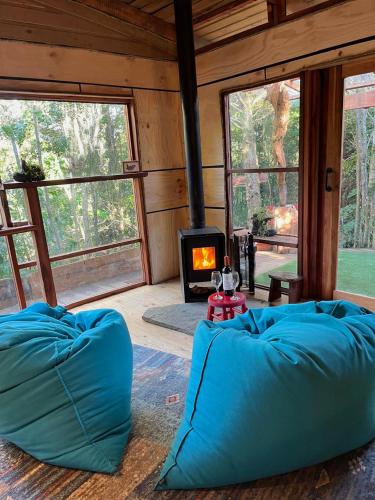 a room with two bean bags in front of a fireplace at Cabañas Los Cantos del Chucao in Puerto Varas