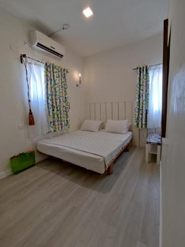 a bedroom with a bed and two windows at Private rooms near the beach center in Tel Aviv