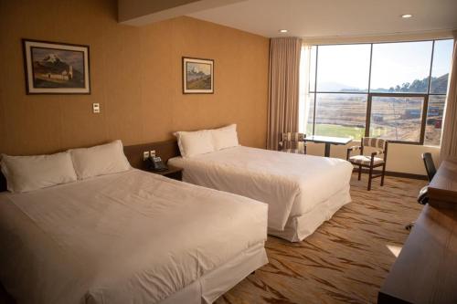 a hotel room with two beds and a window at CAR Sport Hotel Titikaka in Huarina