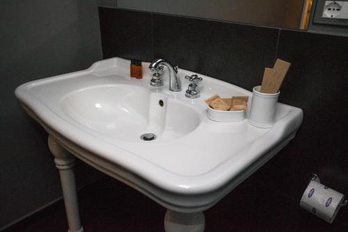 a white sink in a bathroom with toiletries on it at Tra Le Braccia di Morfeo in Terrasini