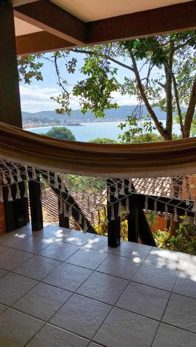 a view of the ocean from a balcony of a house at Pousada Palmeiras Bombinhas in Bombinhas