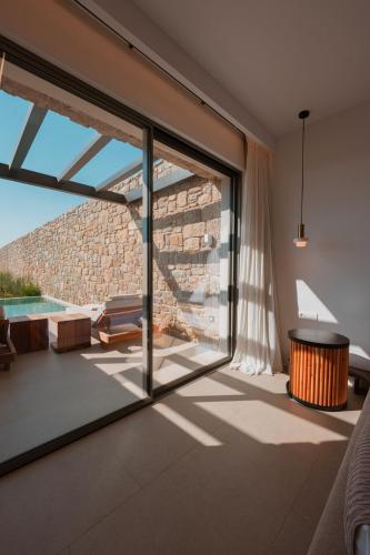 a living room with sliding glass doors and a patio at Muse οf Mykonos Luxury Suites in Mýkonos City