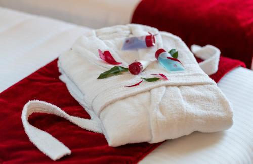 a white towel with flowers on it sitting on a bed at Leonardo Royal Hotel Venice Mestre in Mestre