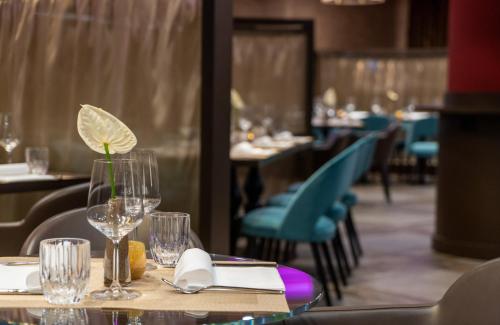 a table in a restaurant with wine glasses on it at Leonardo Royal Hotel Venice Mestre in Mestre