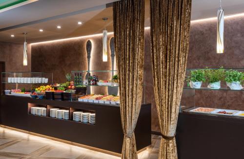 a buffet in a restaurant with curtains and food at Leonardo Royal Hotel Venice Mestre in Mestre