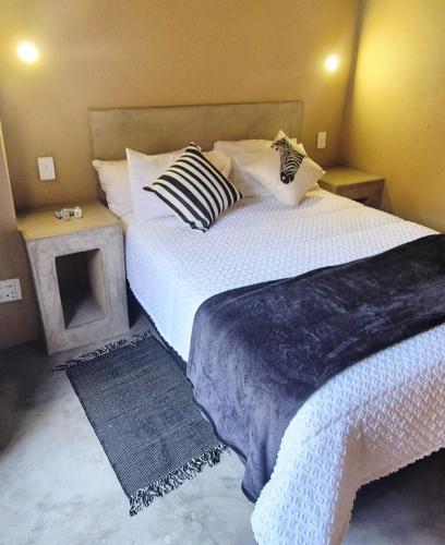 a bedroom with two beds with pillows and a table at Hide Away Wedding,Conference & Function Venue in Bela-Bela