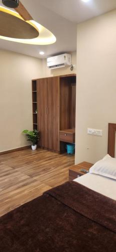 a bedroom with a bed and a wooden floor at Green Suites in Vayalār