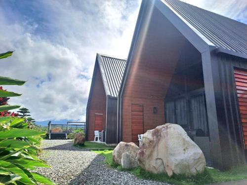 a house with a large rock in front of it at Cabañas Piedra del Risco in Alto Boquete