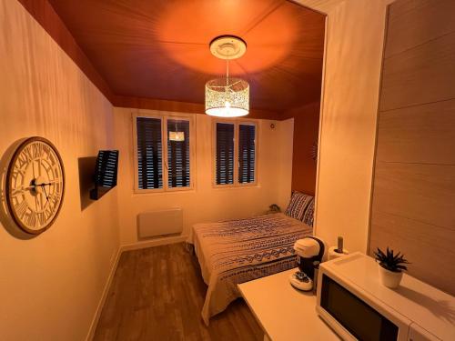 a room with a bed and a clock on the wall at Studio Zen - Paris à 5mn in Alfortville