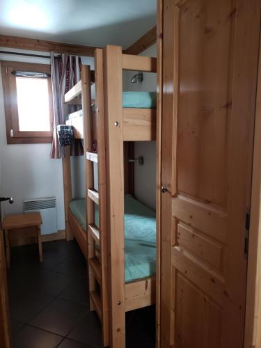 une chambre avec deux lits superposés et une porte dans l'établissement Critérium C02, à Les Champs