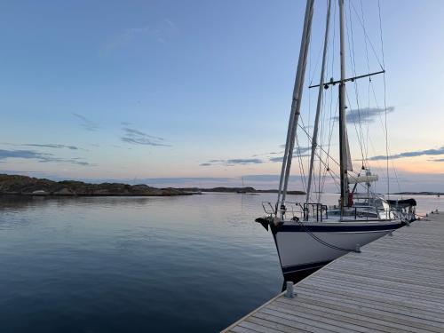 a boat sitting on a dock in the water at Kungshamn - Fisketången in Kungshamn