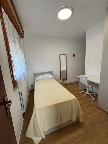a bedroom with a bed and a desk in it at La botte in Ferrara