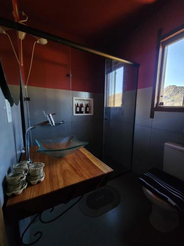 a bathroom with a wooden counter and a sink at Morada da Terra Lapinha da Serra in Santana do Riacho