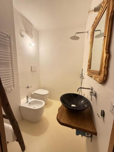 a bathroom with a black sink and a toilet at Le Tre Aie in San Giovanni a Piro