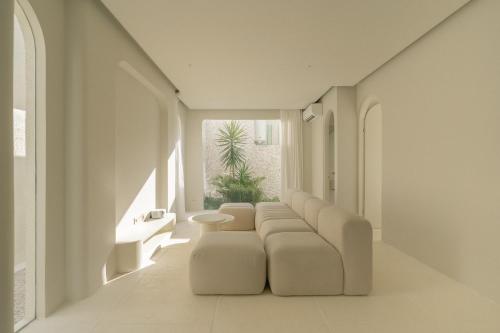 a living room with white furniture and a large window at NOUR Uluwatu in Uluwatu