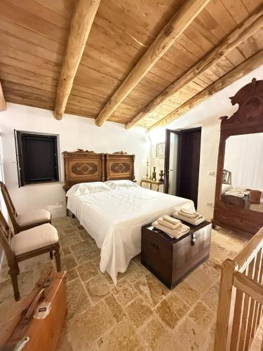a bedroom with a large bed and a chair at Le Tre Aie in San Giovanni a Piro