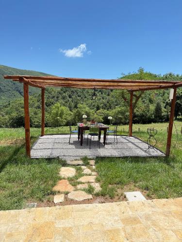 a table and chairs sitting under a wooden pergola at Le Tre Aie in San Giovanni a Piro