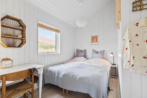 a bedroom with a bed and a desk and a window at 6813-Allinge-Aeblebakken-5 in Allinge