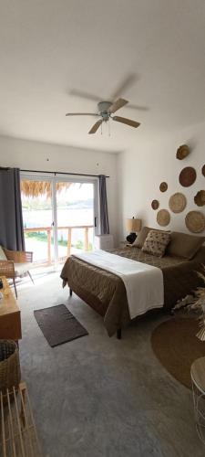 Un dormitorio con una cama grande y un ventilador de techo. en Lemon Tree El Paredon, en El Paredón Buena Vista